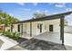 This home features a covered parking area, well-manicured yard, and black and white landscape at 4461 Shore Acres Ne Blvd, St Petersburg, FL 33703