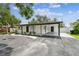 The home features a covered parking area with a well-manicured yard, and black and white landscape design at 4461 Shore Acres Ne Blvd, St Petersburg, FL 33703
