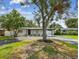 Inviting home with mature trees, lush lawn, and landscaping that enhances curb appeal at 4461 Shore Acres Ne Blvd, St Petersburg, FL 33703