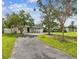 Beautifully landscaped property featuring a well-maintained lawn, mature trees, and a charming single-story home at 4461 Shore Acres Ne Blvd, St Petersburg, FL 33703