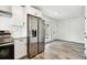 Bright kitchen features stainless steel refrigerator, modern white cabinets, and gray wood-look floors at 4461 Shore Acres Ne Blvd, St Petersburg, FL 33703