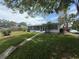 View of the home's backyard, showcasing the lush lawn, screened lanai, and mature trees at 4641 Carson Ne St, St Petersburg, FL 33703
