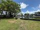 Spacious backyard featuring lush green lawn, mature trees, and waterfront views with dock access at 4641 Carson Ne St, St Petersburg, FL 33703