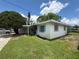 View of the home's exterior shows it has a neat lawn, mature tree, and screened front porch at 4641 Carson Ne St, St Petersburg, FL 33703