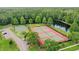 Overhead view highlighting tennis and basketball courts, pond, and natural surroundings in the community at 4948 Ridgemoor Cir, Palm Harbor, FL 34685