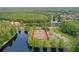 Community aerial view showcasing tennis and basketball courts, lake, and lush green trees around the area at 4948 Ridgemoor Cir, Palm Harbor, FL 34685
