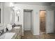 Well-lit bathroom with double sinks, granite countertops, and a glass-enclosed shower at 4948 Ridgemoor Cir, Palm Harbor, FL 34685