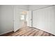 This bedroom with wood floors leads into another room and has a large closet with white doors at 4948 Ridgemoor Cir, Palm Harbor, FL 34685