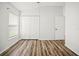 Vacant bedroom featuring wood-look floors, ample natural light, and closet space at 4948 Ridgemoor Cir, Palm Harbor, FL 34685