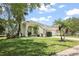 Beautifully landscaped single-story home with a well-manicured lawn and mature tropical landscaping at 4948 Ridgemoor Cir, Palm Harbor, FL 34685
