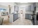 Open kitchen with granite countertops, blue cabinets and stainless appliances, and an island with a breakfast bar at 4948 Ridgemoor Cir, Palm Harbor, FL 34685
