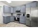 Updated kitchen features blue cabinets, tile backsplash, stainless steel appliances and tile floors at 4948 Ridgemoor Cir, Palm Harbor, FL 34685