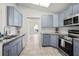 Modern kitchen boasts stylish blue cabinetry, granite countertops, and stainless steel appliances at 4948 Ridgemoor Cir, Palm Harbor, FL 34685