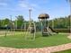 Community playground featuring slides, swings, climbing structures, and soft artificial turf for safe play at 4948 Ridgemoor Cir, Palm Harbor, FL 34685