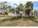 Exterior view of backyard featuring a lush lawn, palm trees, and a white deck, perfect for outdoor relaxation at 5008 Glenn Dr, New Port Richey, FL 34652