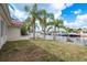 Backyard with a waterfront canal view, featuring a well-maintained lawn and swaying palm trees at 5008 Glenn Dr, New Port Richey, FL 34652