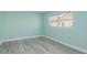 Minimalist bedroom features light blue walls, gray floors, and a window with views at 5008 Glenn Dr, New Port Richey, FL 34652