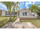 Charming single-story home featuring a well-manicured lawn, palm trees, and a cozy front porch at 5008 Glenn Dr, New Port Richey, FL 34652