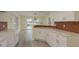 Modern kitchen featuring white cabinets, stainless sink and a view to the dining room at 5008 Glenn Dr, New Port Richey, FL 34652
