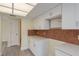 Updated kitchen featuring white cabinets, countertops, tile backsplash, and modern flooring at 5008 Glenn Dr, New Port Richey, FL 34652