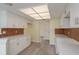 Well-lit kitchen featuring white cabinetry, tile backsplash, and modern flooring at 5008 Glenn Dr, New Port Richey, FL 34652