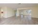 Open-concept living room featuring neutral paint, wood flooring, and abundant natural light at 5008 Glenn Dr, New Port Richey, FL 34652