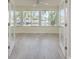 Sun-filled sun room features gray floors, a ceiling fan, and a wall of windows offering canal views at 5008 Glenn Dr, New Port Richey, FL 34652