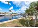 Scenic waterfront view featuring a private dock and lush tropical landscaping under a sunny sky at 5008 Glenn Dr, New Port Richey, FL 34652