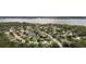 Aerial view showcasing a lakeside community with beautiful homes, mature trees, and a serene pond at 5360 Karlsburg Pl, Palm Harbor, FL 34685