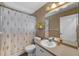 Small bathroom features a shower with floral curtain, toilet, and sink, designed for functionality at 5360 Karlsburg Pl, Palm Harbor, FL 34685