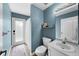 Cozy bathroom featuring blue walls, white fixtures, and a glass door leading to the shower at 5360 Karlsburg Pl, Palm Harbor, FL 34685