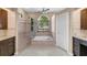 Bright bathroom with walk-in shower, soaking tub, and modern fixtures at 5360 Karlsburg Pl, Palm Harbor, FL 34685