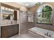 Ensuite bathroom with large shower, soaking tub, and vanity with ample storage at 5360 Karlsburg Pl, Palm Harbor, FL 34685