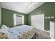 Comfortable green bedroom features a floral bedspread, closet, and window for a relaxing retreat at 5360 Karlsburg Pl, Palm Harbor, FL 34685