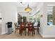 Dining room showcasing modern light fixture, wood table and chairs, and open-concept design at 5360 Karlsburg Pl, Palm Harbor, FL 34685