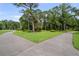 Beautiful property grounds with manicured lawns, lush landscaping, and a meandering driveway at 5360 Karlsburg Pl, Palm Harbor, FL 34685