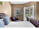 Cozy main bedroom with king bed, sitting area, and view of pool and outdoor living area at 5360 Karlsburg Pl, Palm Harbor, FL 34685