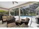 Outdoor seating area featuring comfortable furnishings and a screened pool view at 5360 Karlsburg Pl, Palm Harbor, FL 34685