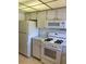 Functional kitchen featuring white appliances, tile backsplash, and ample cabinet space at 5623 80Th N St # 314, St Petersburg, FL 33709