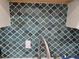 Close-up of the kitchen's unique green patterned tile backsplash at 5925 Terrace Park N Dr # 210, St Petersburg, FL 33709