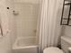 Bright bathroom showcasing a tub with white tiling, shower, and a white curtain at 5925 Terrace Park N Dr # 210, St Petersburg, FL 33709