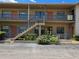 Exterior view of a two-story building with colorful entry doors and well-maintained landscaping at 5925 Terrace Park N Dr # 210, St Petersburg, FL 33709