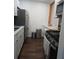 Modern kitchen featuring white cabinets, stainless steel appliances, and dark wood flooring at 5925 Terrace Park N Dr # 210, St Petersburg, FL 33709