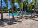 Fenced community pool area with lush palm trees and brick paved deck at 5925 Terrace Park N Dr # 210, St Petersburg, FL 33709