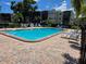 Community pool and lounge area surrounded by brick paving and landscaping at 5925 Terrace Park N Dr # 210, St Petersburg, FL 33709