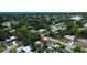 An aerial view shows the home nestled in a tree-filled neighborhood with glimpses of a nearby pond at 5998 8Th S St, St Petersburg, FL 33705