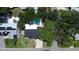Aerial view of a home with a backyard pool, mature trees, and solar panels on a neighboring roof at 5998 8Th S St, St Petersburg, FL 33705