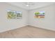 Bright bedroom with neutral paint, light wood floors, a ceiling fan and two windows at 5998 8Th S St, St Petersburg, FL 33705