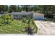 A well-maintained single-Gathering home with a lush front yard, mature trees, and an attached garage at 5998 8Th S St, St Petersburg, FL 33705