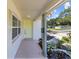 Covered front porch with a yellow door, lush plants, and decorative landscaping at 5998 8Th S St, St Petersburg, FL 33705